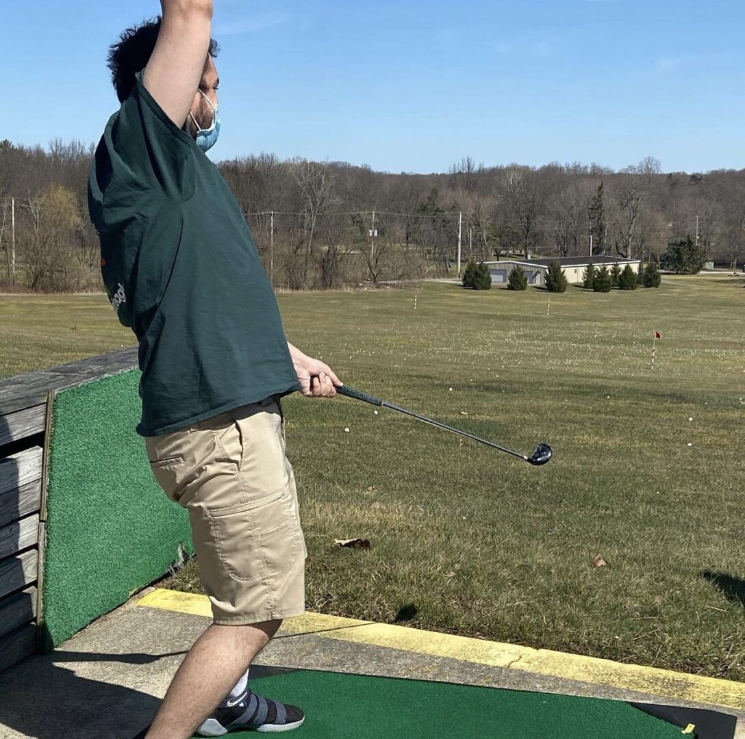 A man with hands up playing golf
